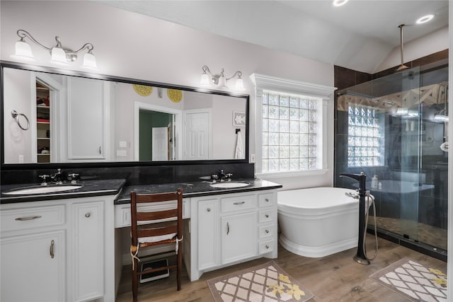 bathroom featuring vanity, wood-type flooring, shower with separate bathtub, and vaulted ceiling