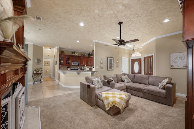 living room with ceiling fan, light colored carpet, ornamental molding, and a textured ceiling