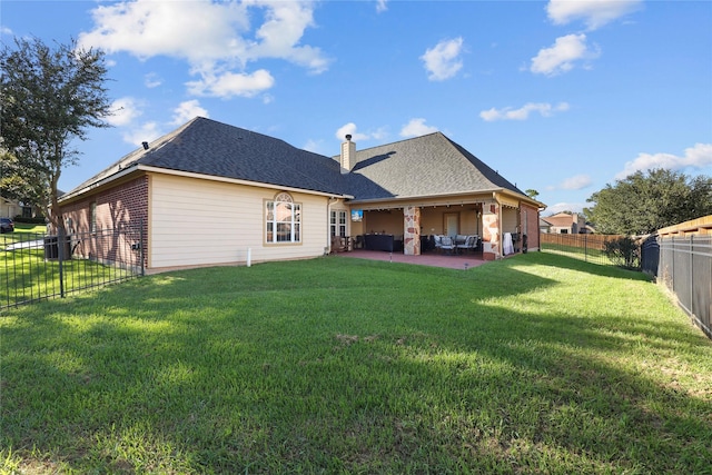 rear view of house featuring a yard and a patio