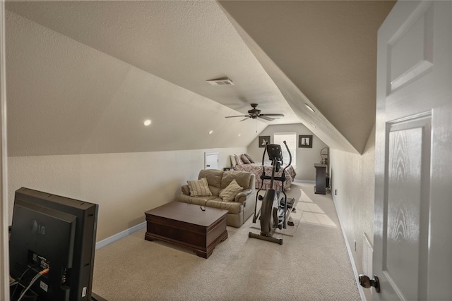 exercise area featuring a textured ceiling, light carpet, ceiling fan, and vaulted ceiling