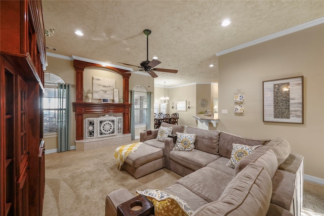 carpeted living room featuring ceiling fan, ornamental molding, and a textured ceiling