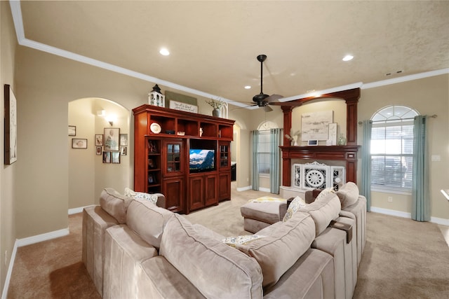 living room with ceiling fan, light colored carpet, and ornamental molding