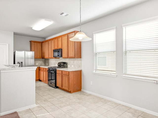 kitchen featuring hanging light fixtures, light tile patterned floors, tasteful backsplash, and black appliances