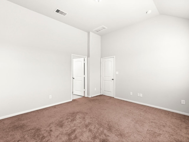 empty room featuring carpet and vaulted ceiling