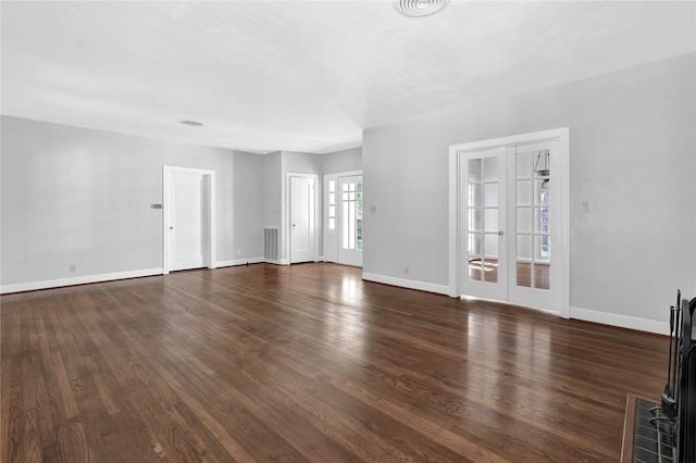 unfurnished living room featuring dark hardwood / wood-style floors and french doors