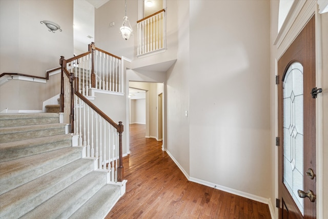 entryway featuring a towering ceiling and hardwood / wood-style flooring