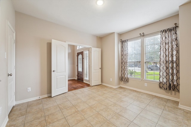 unfurnished bedroom with light tile patterned floors and multiple windows