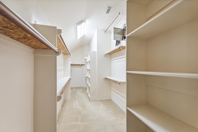 walk in closet featuring light colored carpet