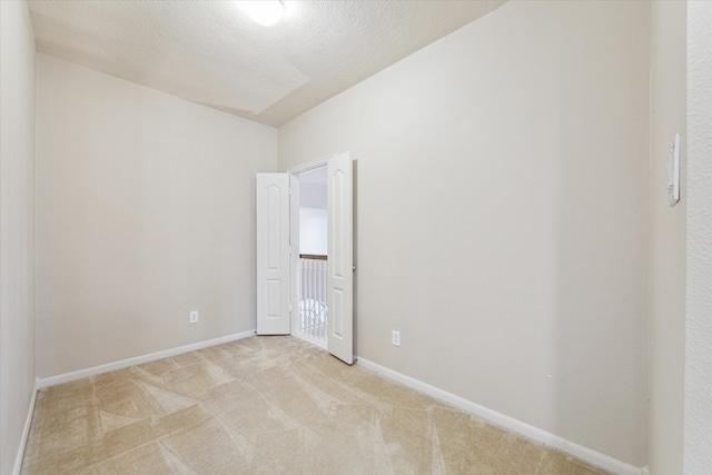 carpeted spare room with a textured ceiling