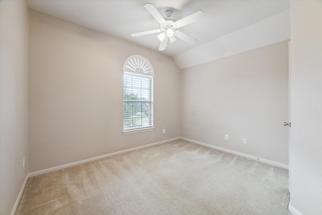 carpeted empty room featuring vaulted ceiling and ceiling fan