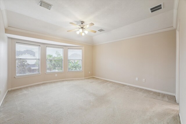 empty room featuring ceiling fan, lofted ceiling, light carpet, and crown molding