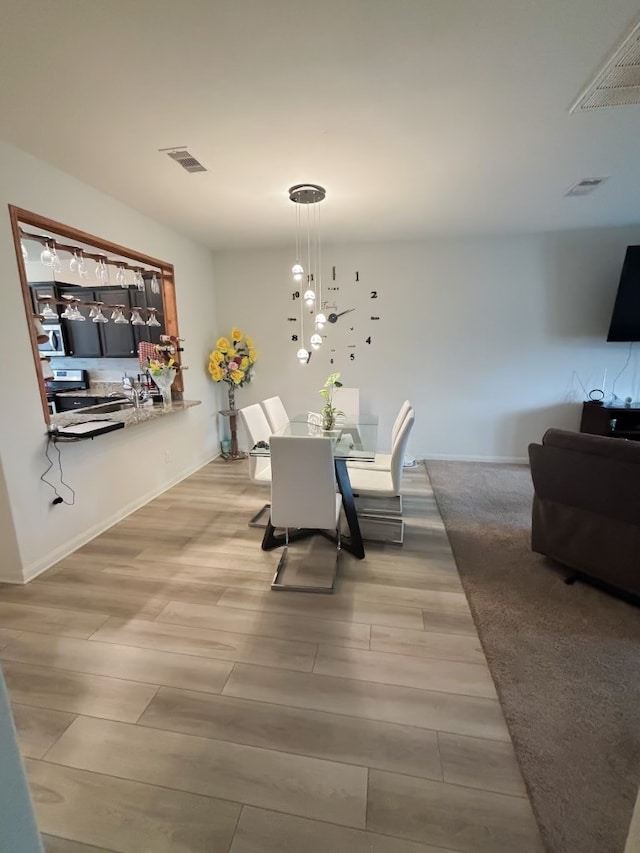 dining room with light hardwood / wood-style flooring and a chandelier