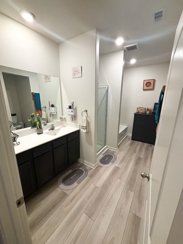 bathroom with vanity, hardwood / wood-style floors, and an enclosed shower