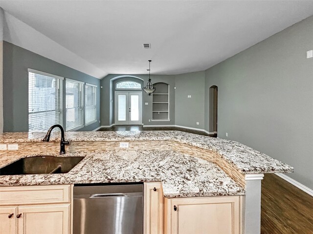 kitchen with vaulted ceiling, dark wood-type flooring, light stone counters, dishwasher, and sink