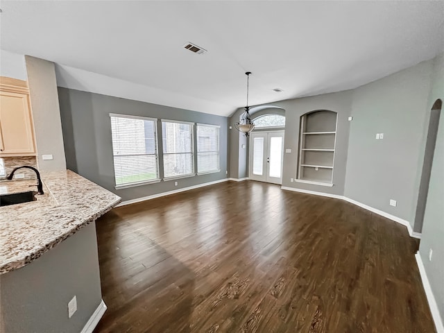 interior space with dark wood-type flooring, built in features, french doors, and sink