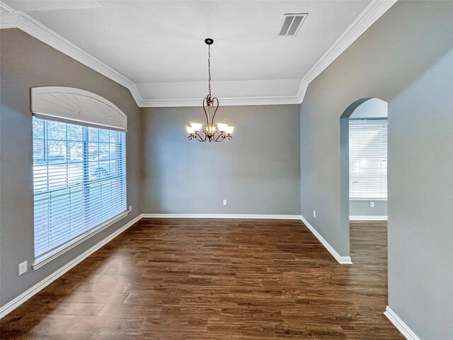 spare room featuring crown molding, dark wood-type flooring, and a chandelier