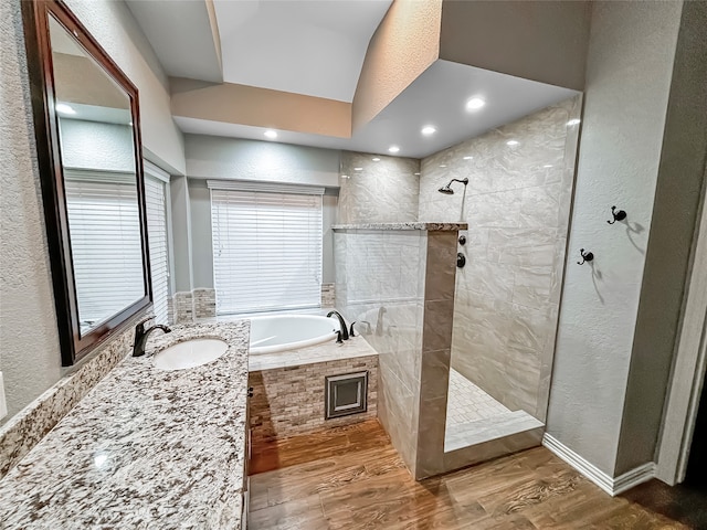 bathroom featuring vanity, shower with separate bathtub, lofted ceiling, and hardwood / wood-style floors