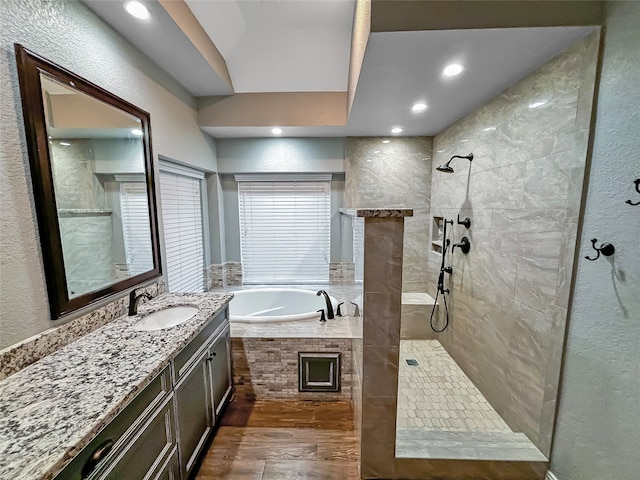 bathroom with independent shower and bath, vanity, and wood-type flooring