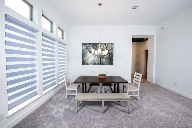 dining room with carpet floors and a chandelier