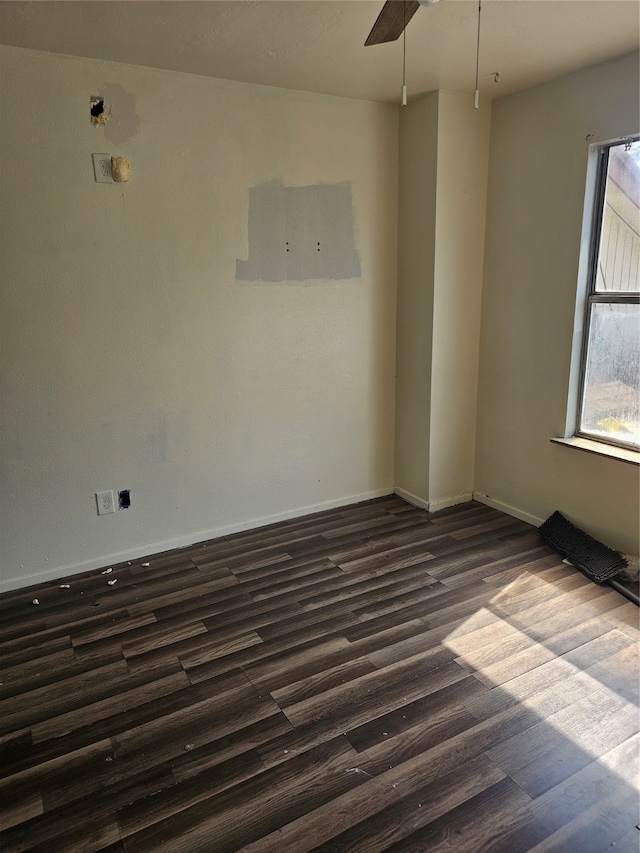 empty room with ceiling fan and dark hardwood / wood-style flooring