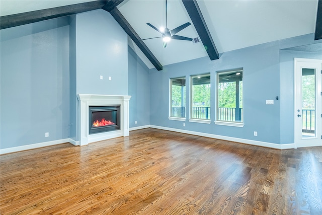 unfurnished living room with high vaulted ceiling, beam ceiling, ceiling fan, and hardwood / wood-style floors