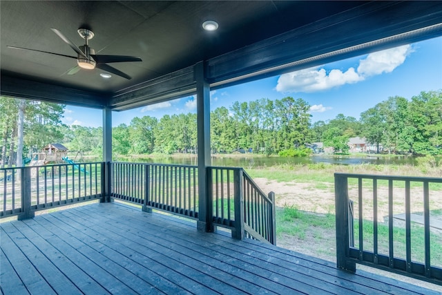 deck with a playground, a water view, and ceiling fan