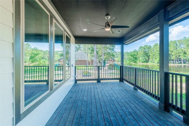 deck featuring ceiling fan and a water view