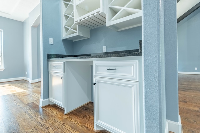 bar with white cabinets and hardwood / wood-style flooring