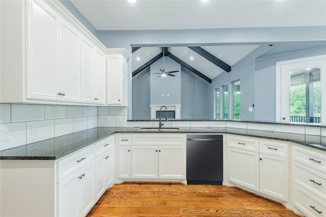 kitchen featuring vaulted ceiling with beams, white cabinets, and sink