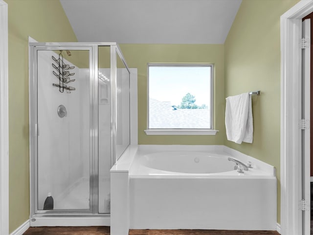 bathroom with plus walk in shower, wood-type flooring, and vaulted ceiling