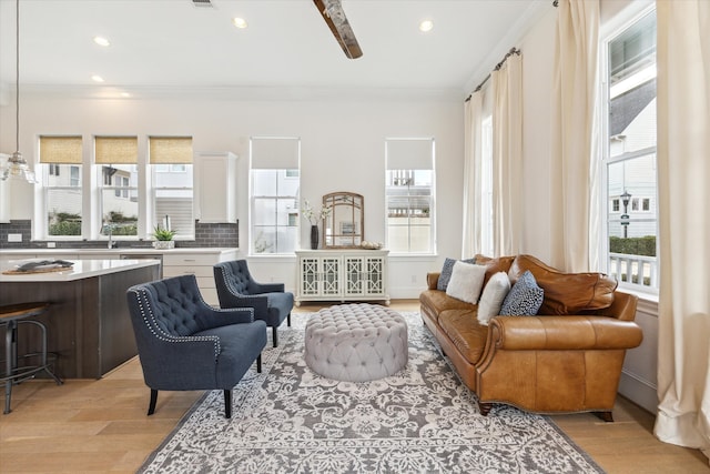 living room with light wood-type flooring and crown molding