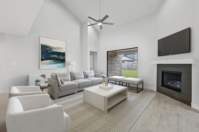 living room featuring high vaulted ceiling, ceiling fan, and light wood-type flooring