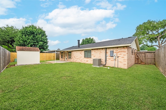 rear view of house with a shed, a yard, a patio, and cooling unit