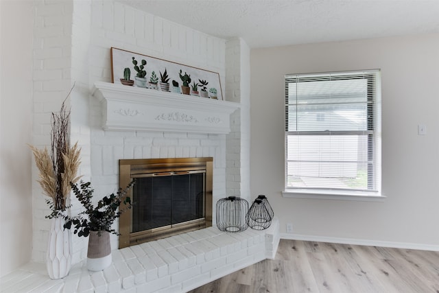 interior details featuring a fireplace, wood-type flooring, and a textured ceiling