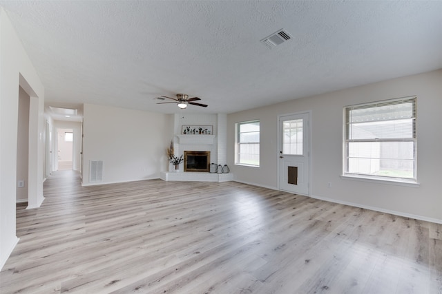 unfurnished living room featuring light wood-type flooring, a textured ceiling, and ceiling fan