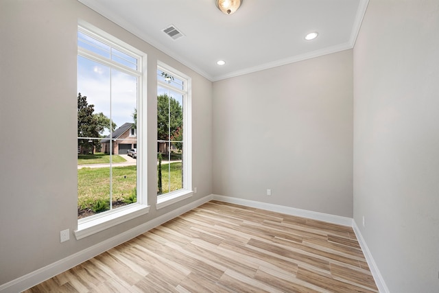 unfurnished room with ornamental molding, plenty of natural light, and light hardwood / wood-style floors