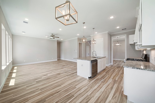 kitchen featuring appliances with stainless steel finishes, white cabinetry, an island with sink, ceiling fan with notable chandelier, and pendant lighting