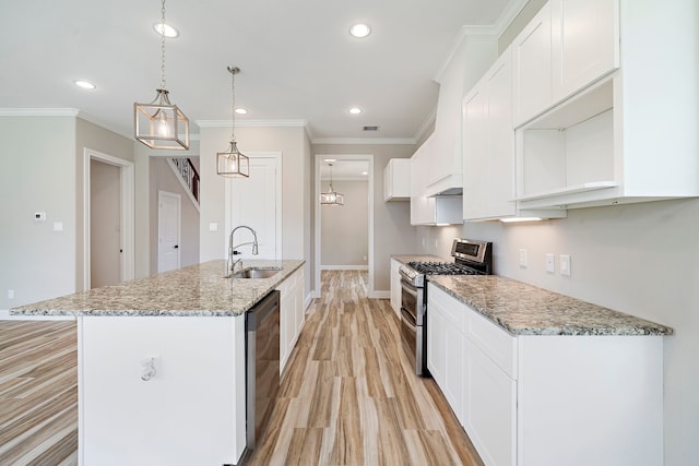 kitchen with appliances with stainless steel finishes, sink, an island with sink, and white cabinets