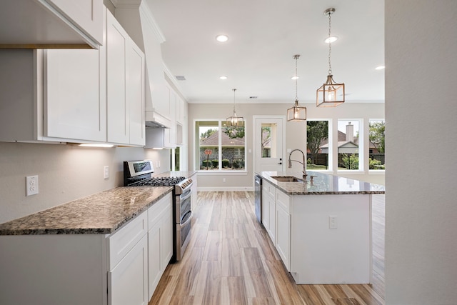 kitchen with white cabinets, appliances with stainless steel finishes, hanging light fixtures, and sink