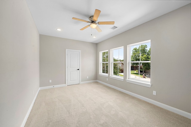 spare room featuring ceiling fan and light carpet