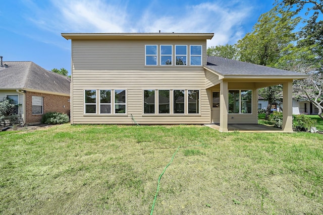 rear view of house featuring a lawn and a patio