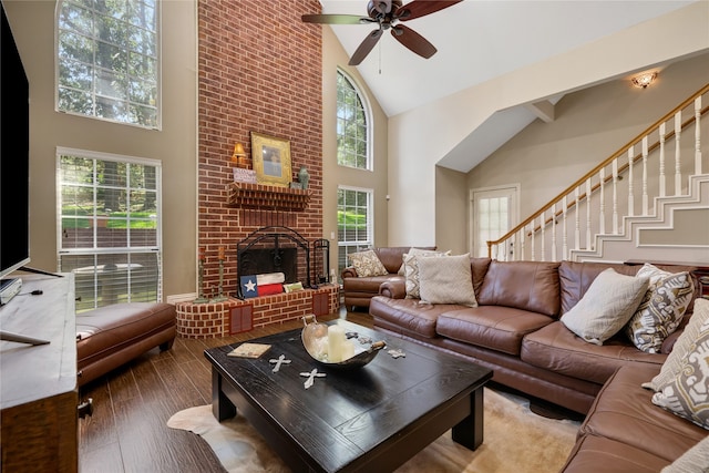 living room with plenty of natural light, ceiling fan, a brick fireplace, and high vaulted ceiling