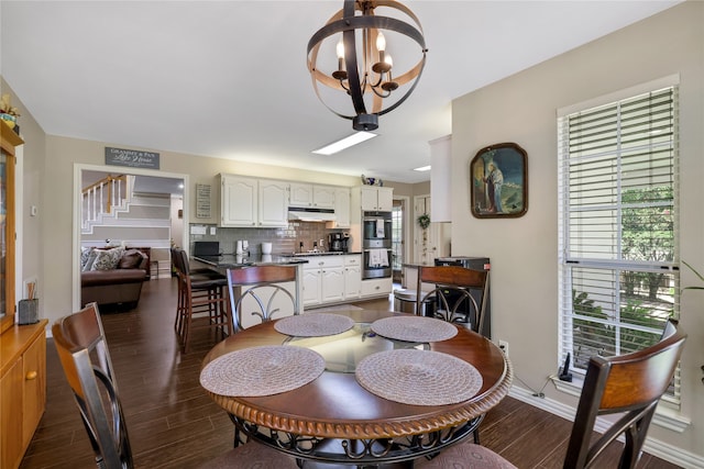 dining space featuring dark hardwood / wood-style flooring and a notable chandelier