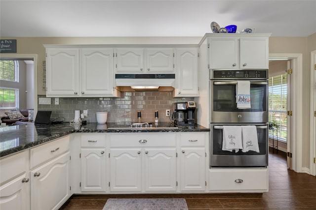 kitchen featuring white cabinets, double oven, and dark wood-type flooring