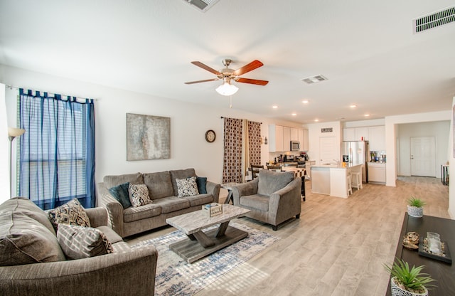 living room with light wood-type flooring and ceiling fan