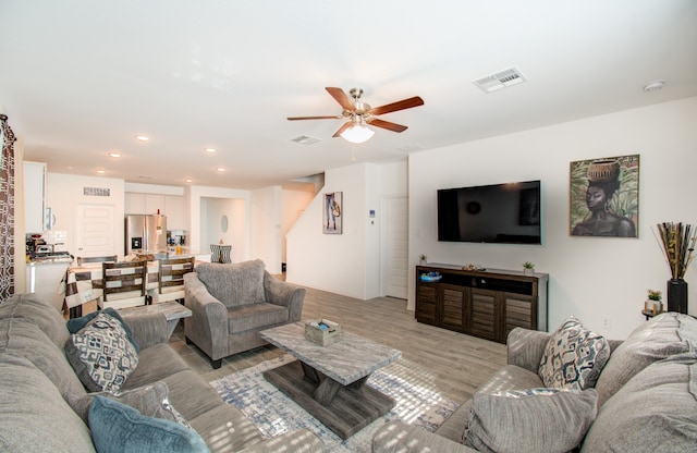 living room featuring ceiling fan and light wood-type flooring