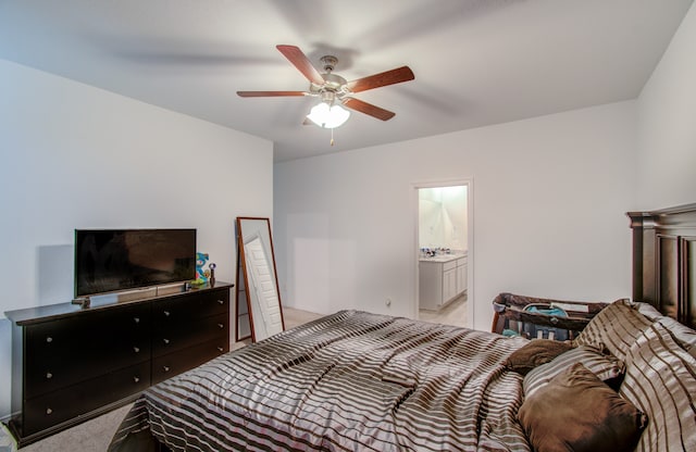 bedroom featuring ceiling fan, ensuite bath, and light carpet