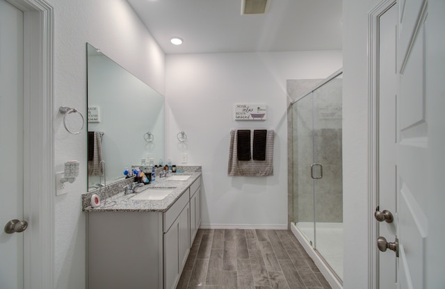 bathroom featuring an enclosed shower, hardwood / wood-style flooring, and vanity