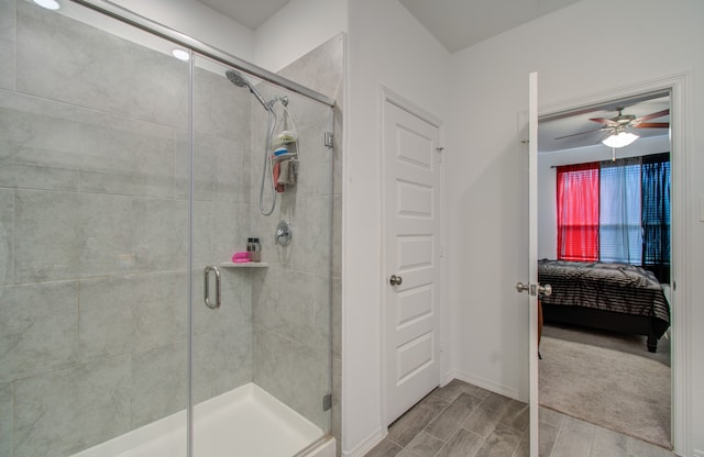 bathroom featuring ceiling fan and a shower with shower door