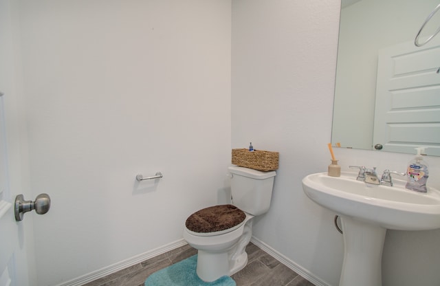 bathroom featuring hardwood / wood-style flooring and toilet